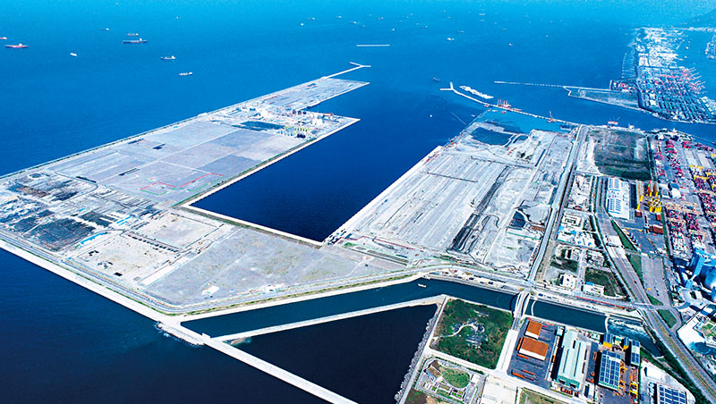 可停靠2.4萬TEU大船的高雄第七貨櫃中心，預計2023年5月啟用，長榮海運將進駐。台灣港務公司董事長李賢義樂觀表示，有助招攬其他港口的轉運業務到高雄港，是鞏固樞紐地位的關鍵建設